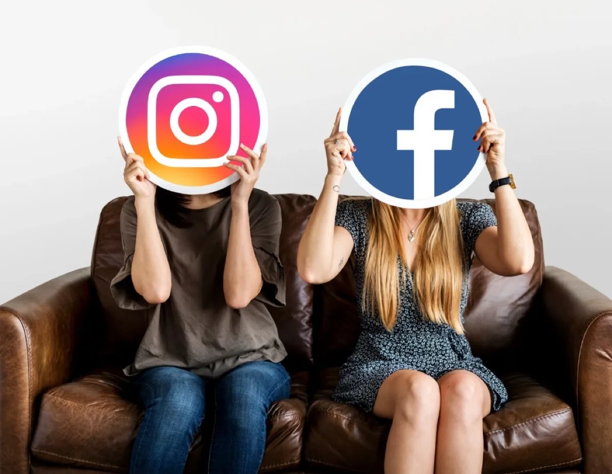 Zwei Personen halten runde Schilder mit Instagram- und Facebook-Logo — Symbol für die Wahl der passenden Social-Media-Plattform