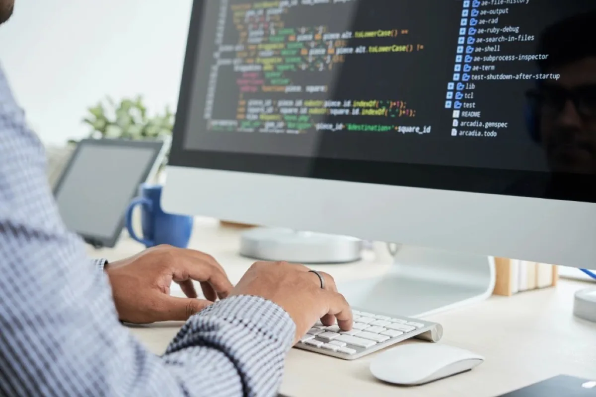 Webentwickler programmiert eine Website an einem grossen Monitor in einem modernen Büro